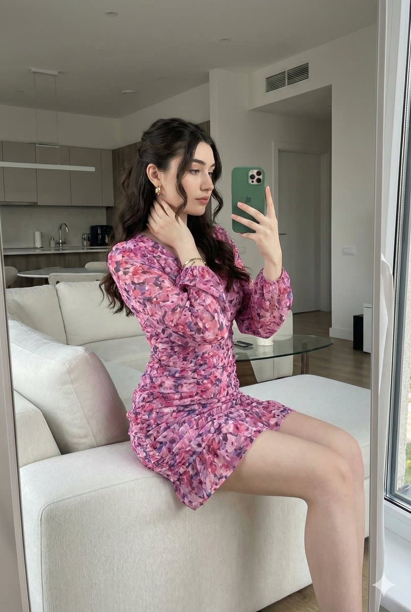 Young woman taking a mirror selfie inside a modern living room.