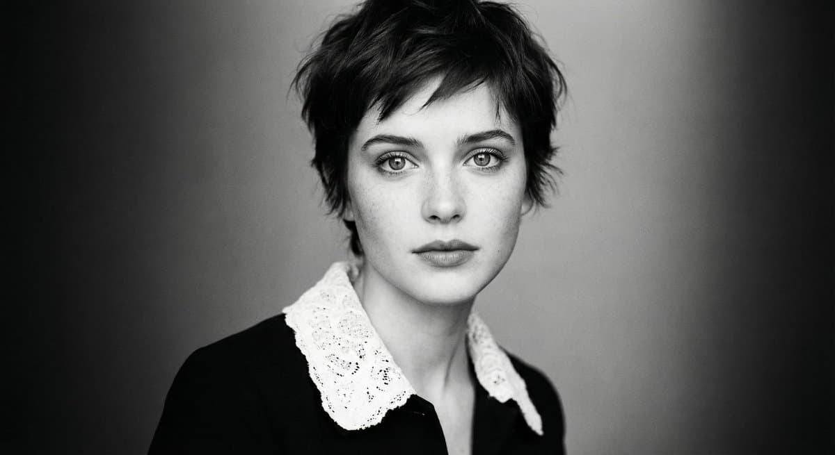 A cinematic, ultra-realistic monochrome portrait of a young woman with expres...